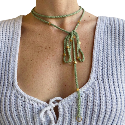 Doppio Senso Dettagli Oro È NA ROBA: collana artigianale in cotone verde salvia con perline dorate, indossata come lariat